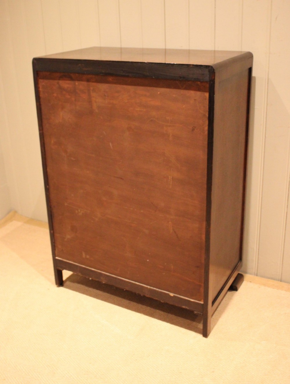 A dark brown oak Art Deco chest of drawers featuring five stacked drawers with matching wood handles and stepped feet. View XI