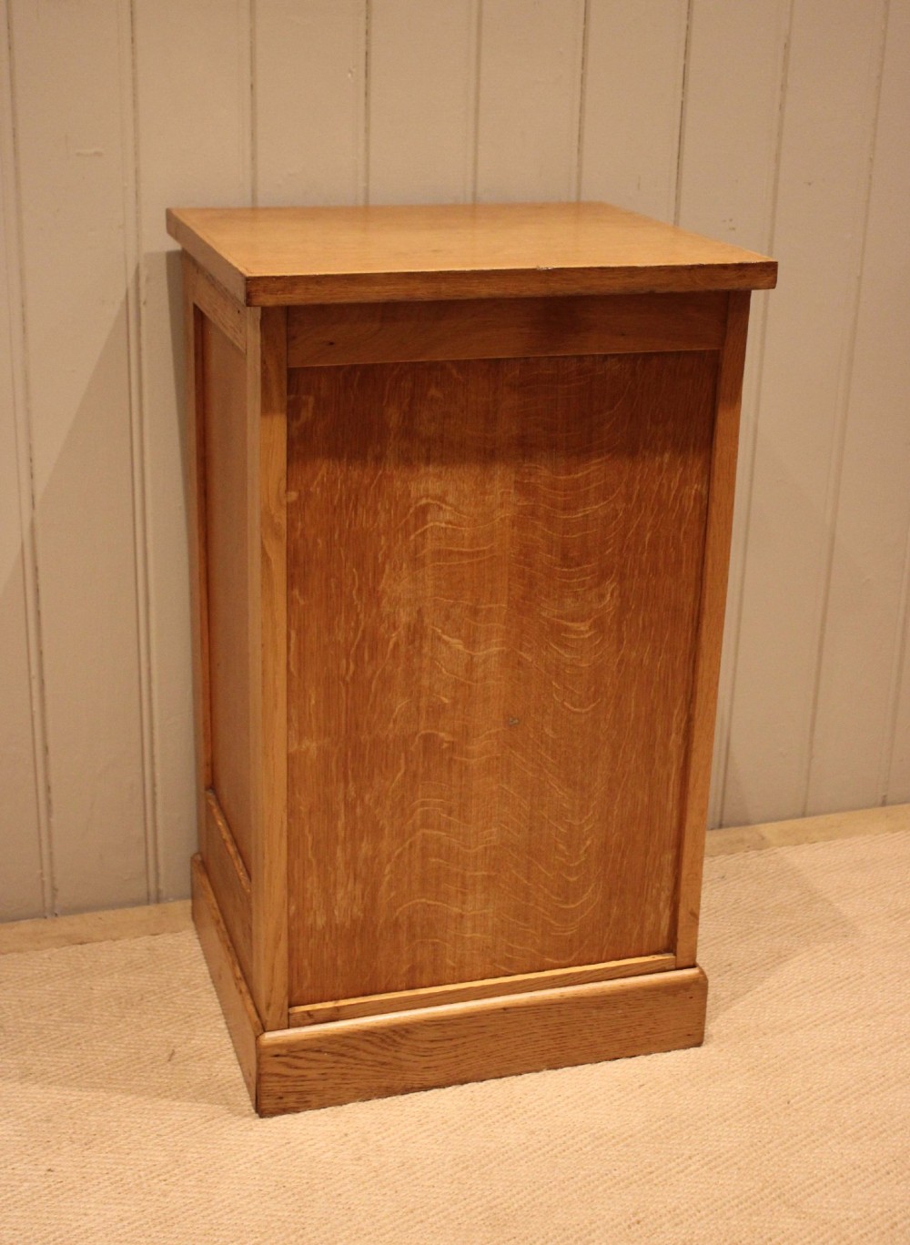 A small light oak filing cabinet featuring a slatted wooden tambour front with a metal handle and keyhole lock at the top. View XI
