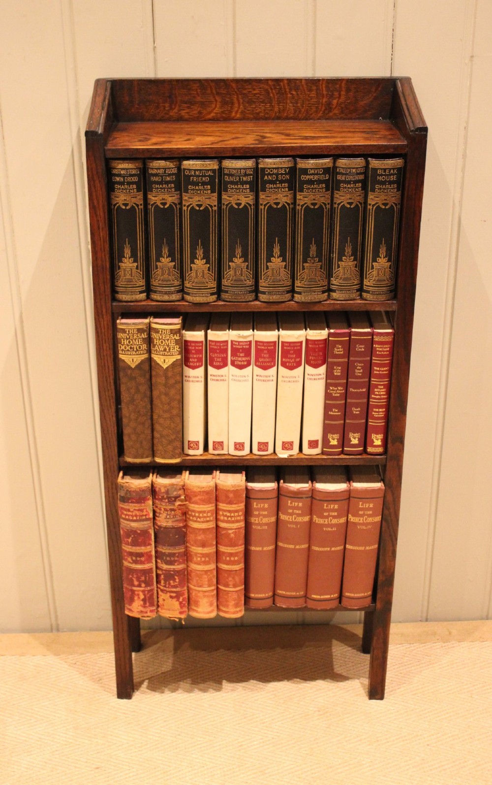 A tall, narrow Edwardian dark oak open-back bookcase featuring four horizontal shelves and straight square legs. View V