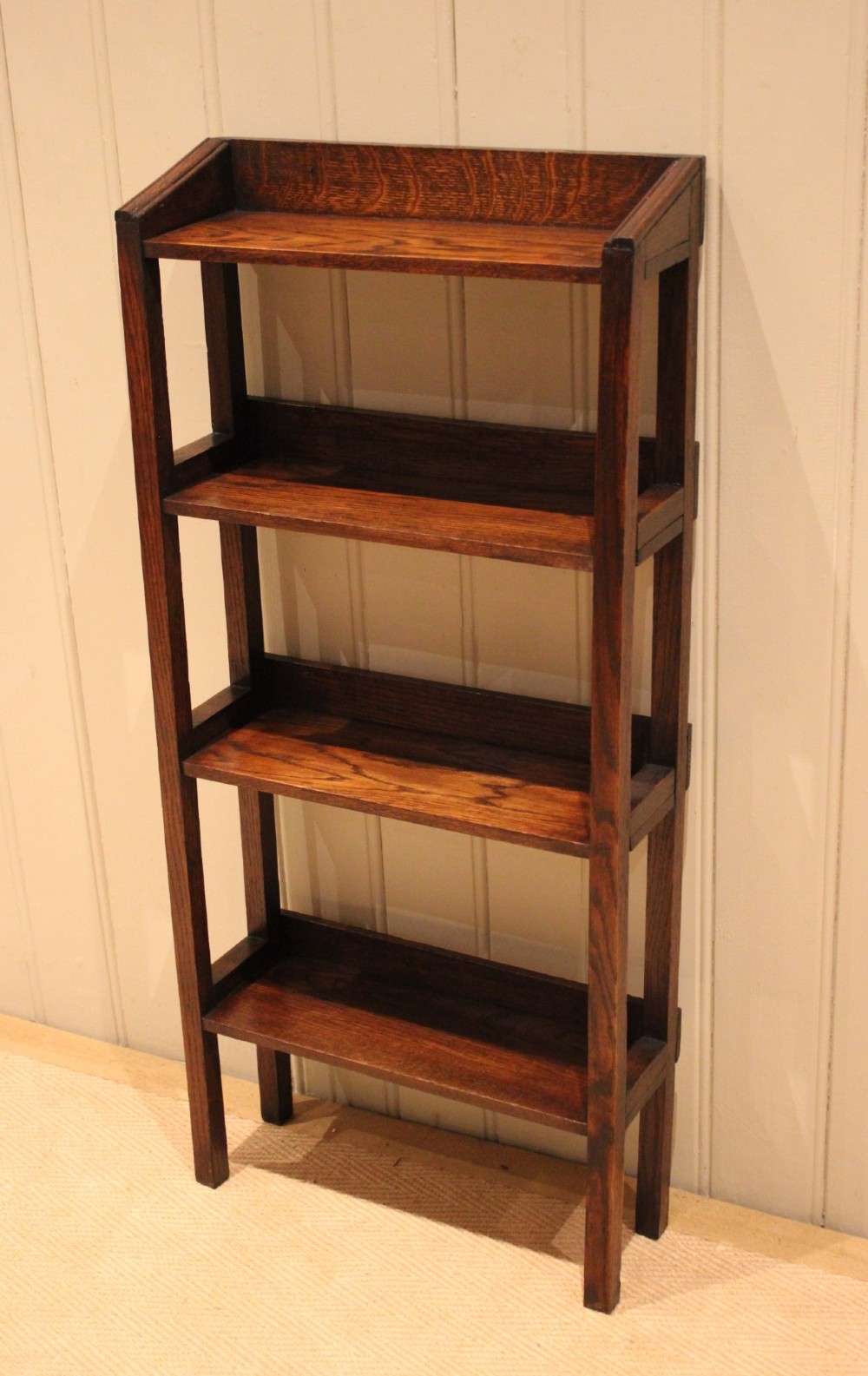 A tall, narrow Edwardian dark oak open-back bookcase featuring four horizontal shelves and straight square legs. View VIII