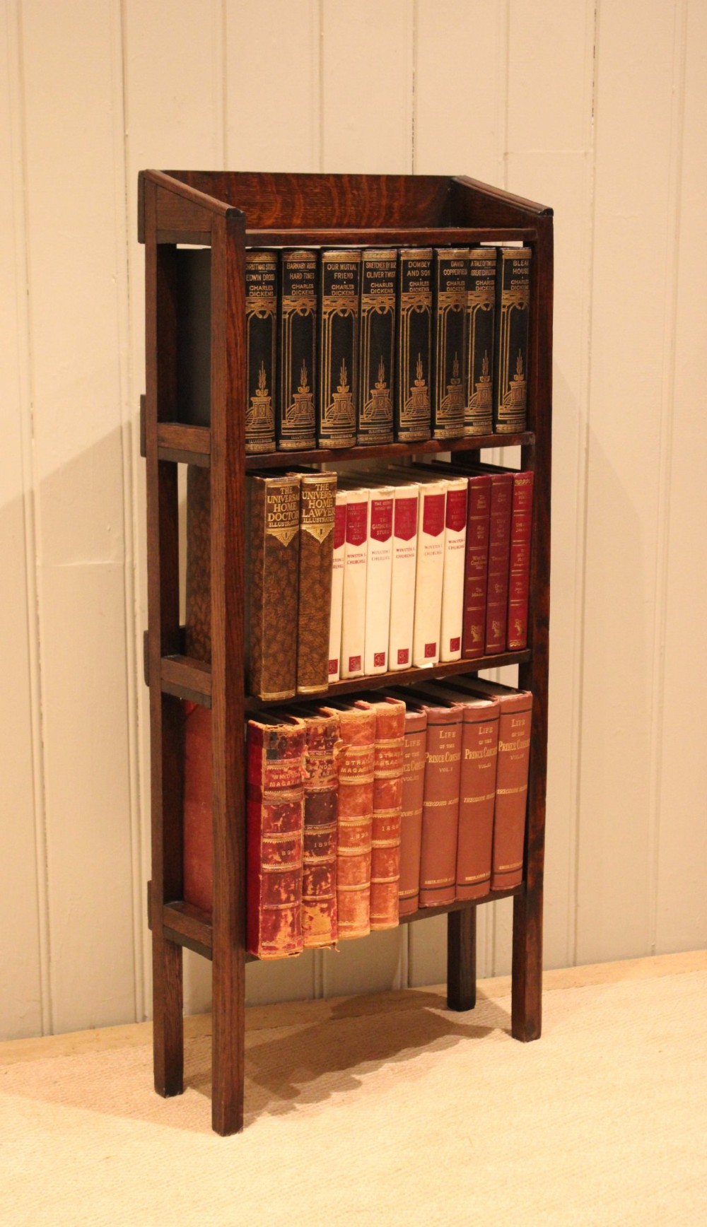 A tall, narrow Edwardian dark oak open-back bookcase featuring four horizontal shelves and straight square legs. View XI