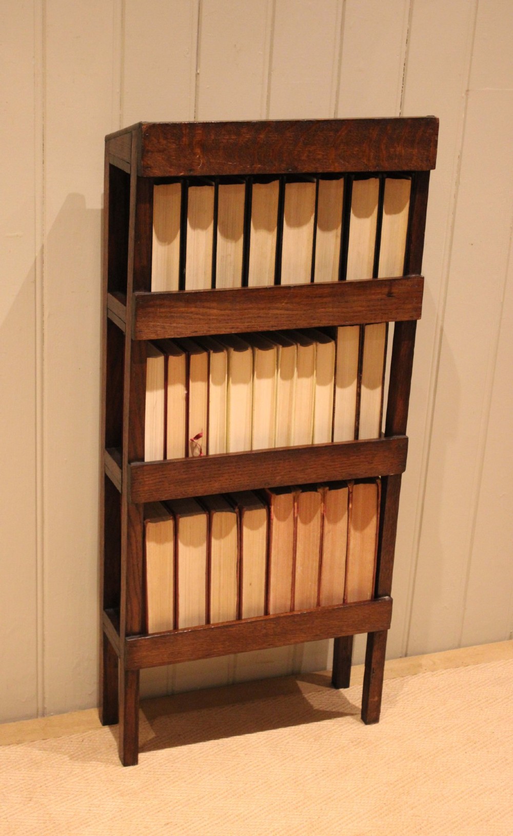 A tall, narrow Edwardian dark oak open-back bookcase featuring four horizontal shelves and straight square legs. View XII