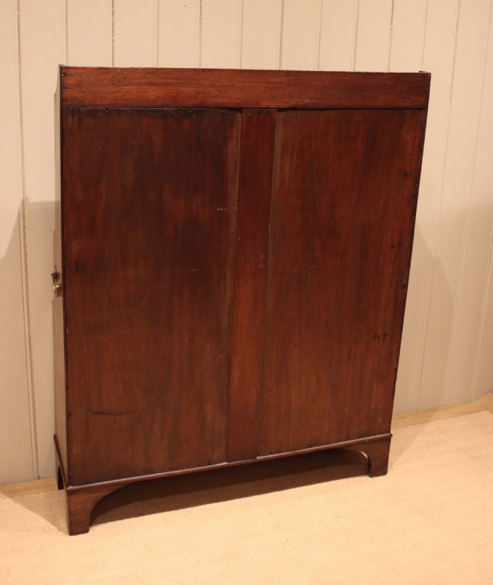 An antique Regency mahogany open bookcase featuring four fixed shelves, graduated side panels, and a shaped apron base. View XIII
