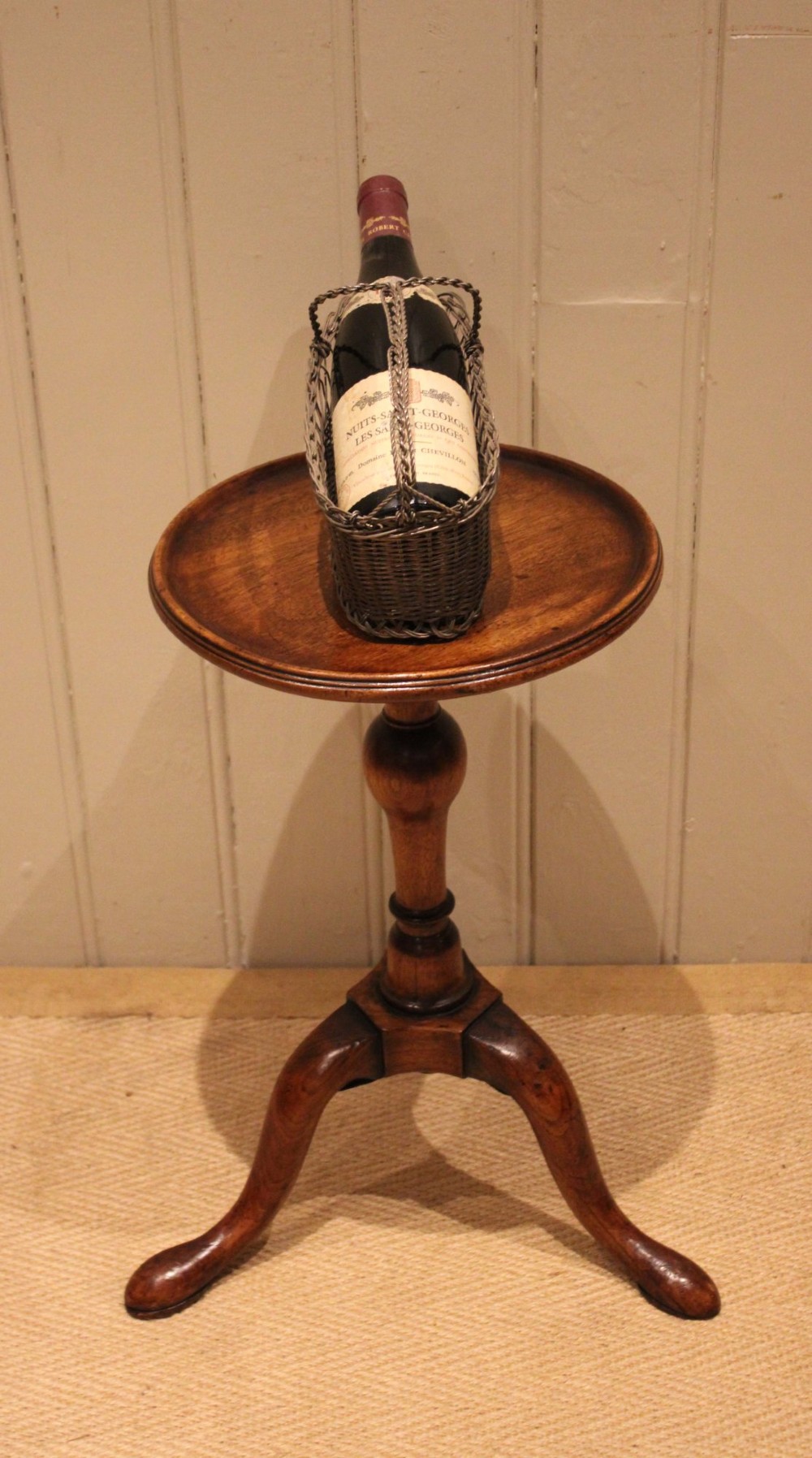 A Georgian mahogany wine table featuring a circular dished top supported by a turned baluster column and tripod pad feet. View III