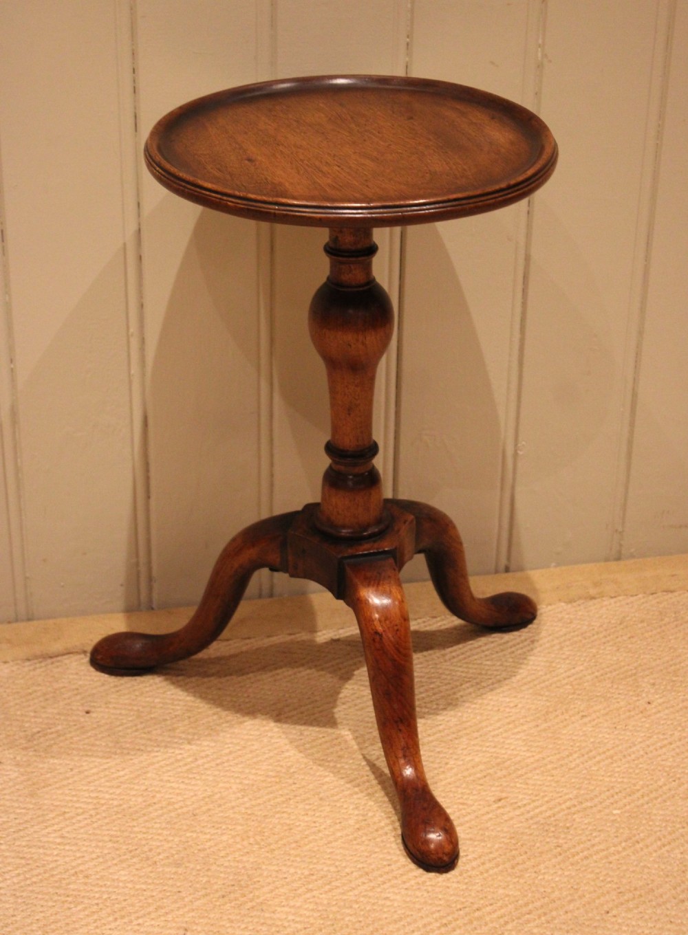 A Georgian mahogany wine table featuring a circular dished top supported by a turned baluster column and tripod pad feet. View IV