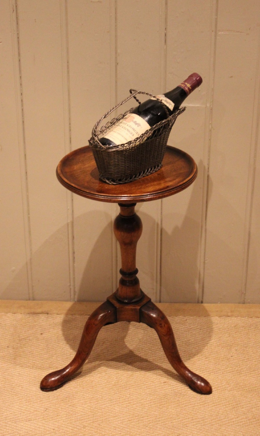 A Georgian mahogany wine table featuring a circular dished top supported by a turned baluster column and tripod pad feet. View VI