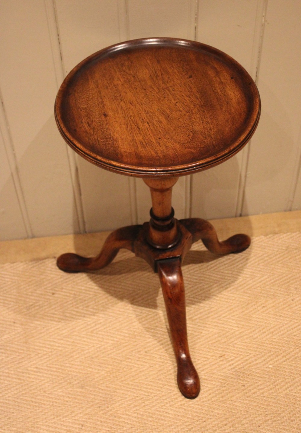A Georgian mahogany wine table featuring a circular dished top supported by a turned baluster column and tripod pad feet. View X