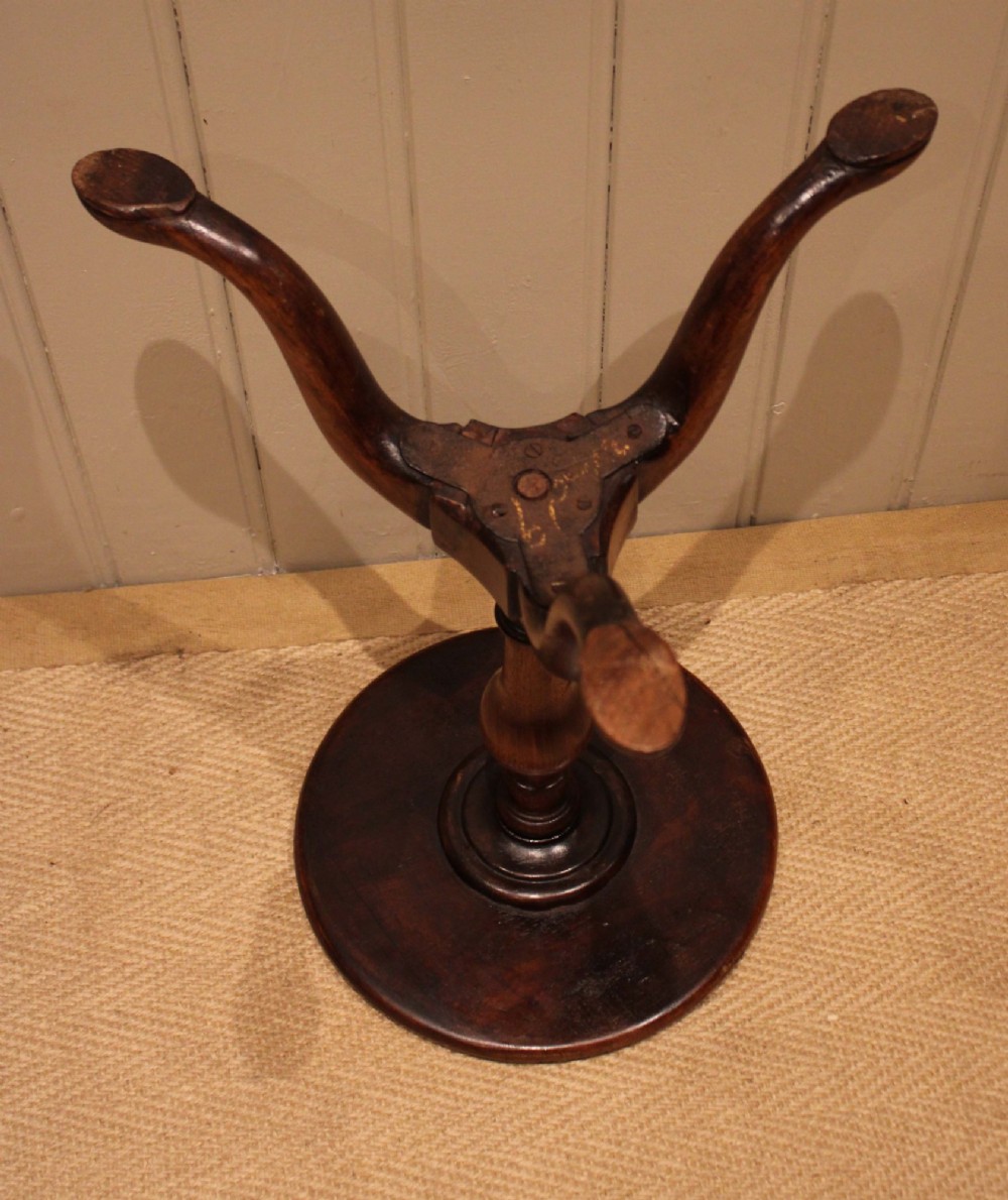 A Georgian mahogany wine table featuring a circular dished top supported by a turned baluster column and tripod pad feet. View XI