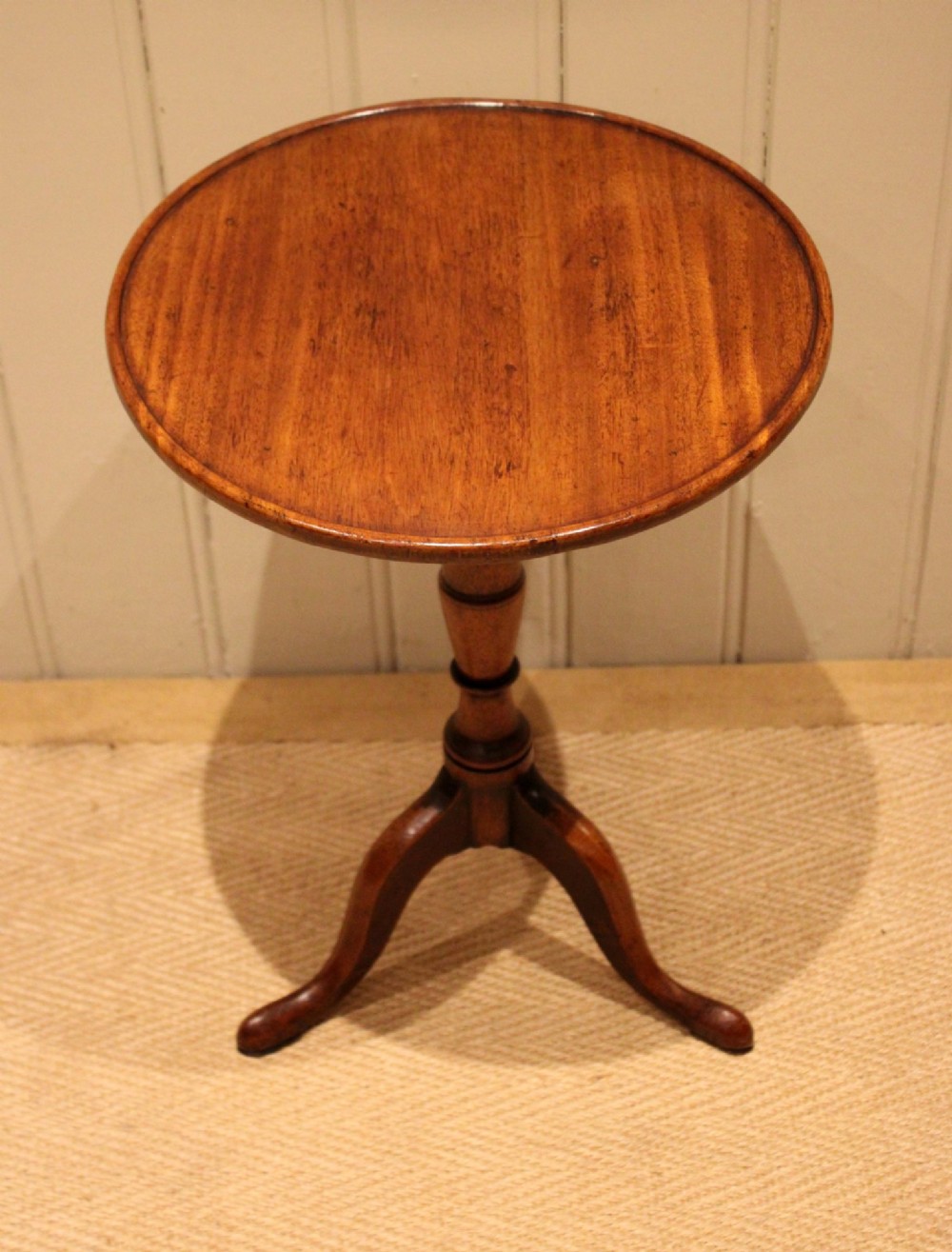 A circular mahogany tilt-top wine table with a turned central pedestal column and a tripod base featuring cabriole legs. View IV