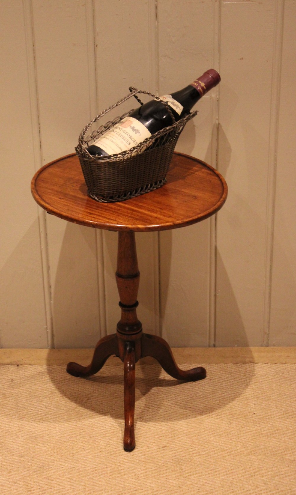 A circular mahogany tilt-top wine table with a turned central pedestal column and a tripod base featuring cabriole legs. View VIII