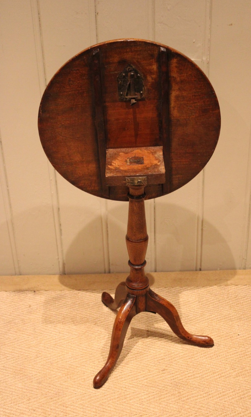 A circular mahogany tilt-top wine table with a turned central pedestal column and a tripod base featuring cabriole legs. View XI