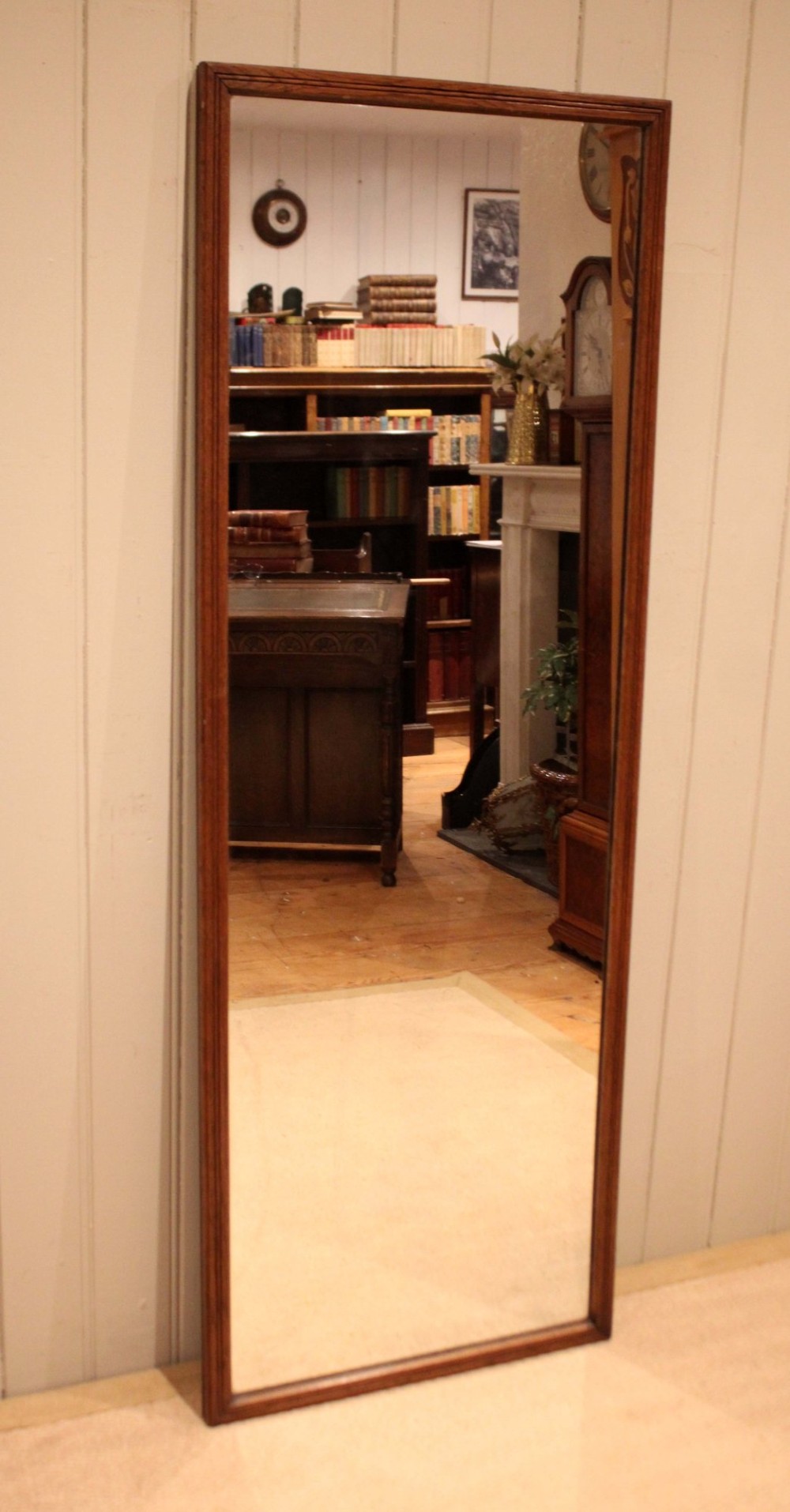 A large rectangular full-length mirror featuring a slender moulded oak frame with visible natural grain.