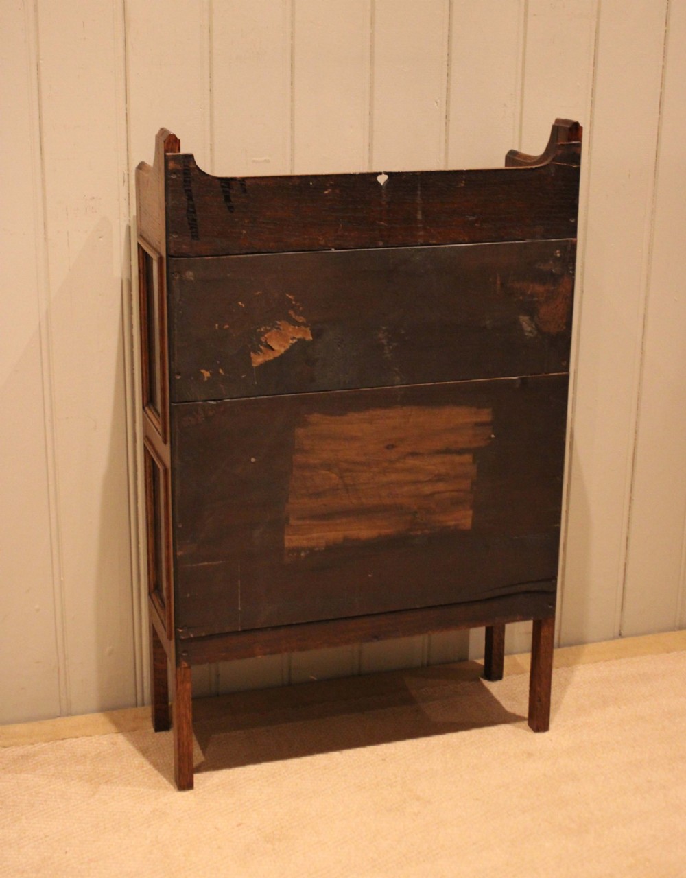 A small Arts and Crafts medium oak glazed bookcase featuring a gallery top with a pierced heart motif, two glazed doors, glazed side panels, and square legs. View XIV