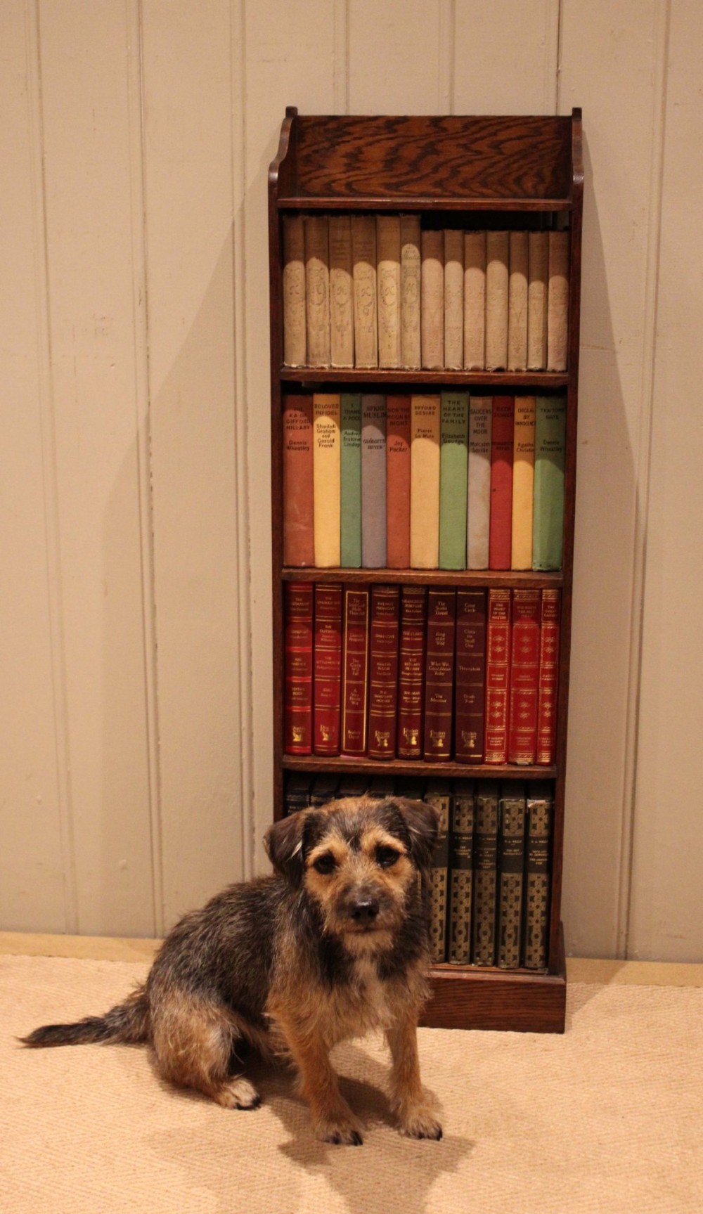 A tall, narrow dark oak open bookcase featuring multiple shelves, a shaped gallery top, and a solid plinth base. View XII