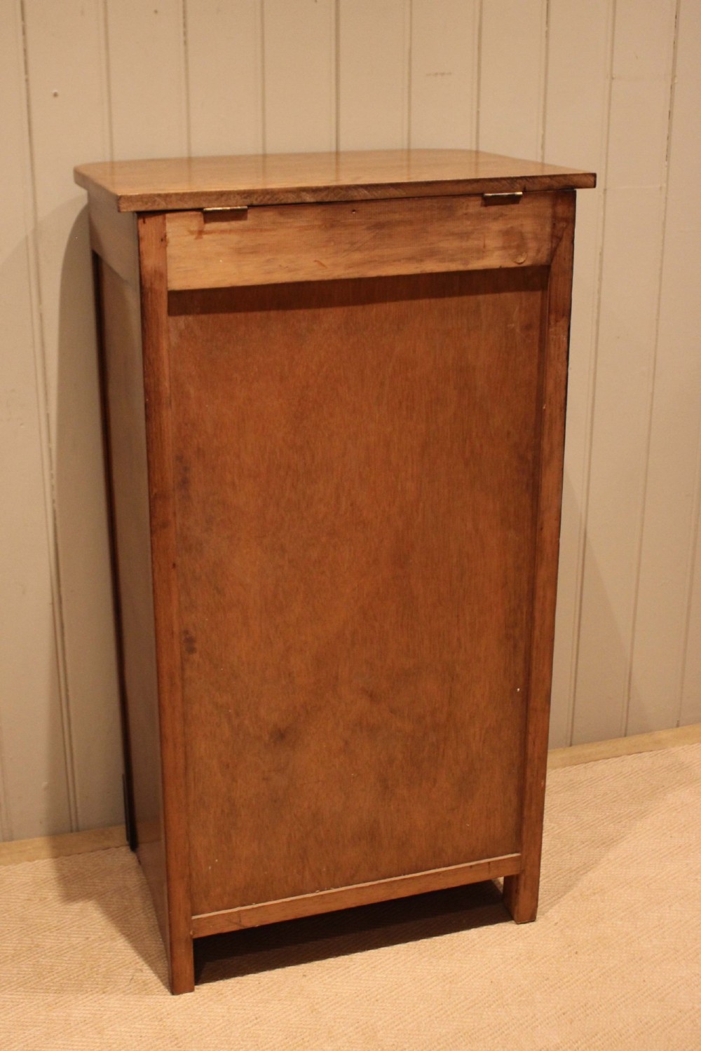 A tall oak chest of drawers featuring five drawers with metal cup handles and reeded side detailing. View XII
