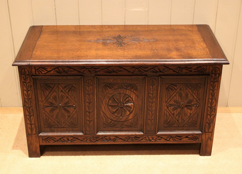 A rectangular dark oak storage coffer featuring three hand-carved front panels with rosette and geometric motifs. View IV