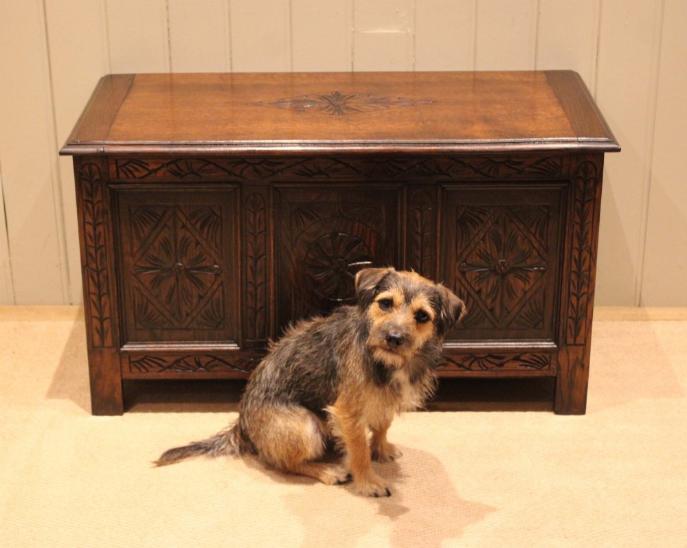 A rectangular dark oak storage coffer featuring three hand-carved front panels with rosette and geometric motifs. View VII