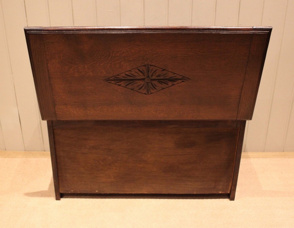 A rectangular dark oak storage coffer featuring three hand-carved front panels with rosette and geometric motifs. View X