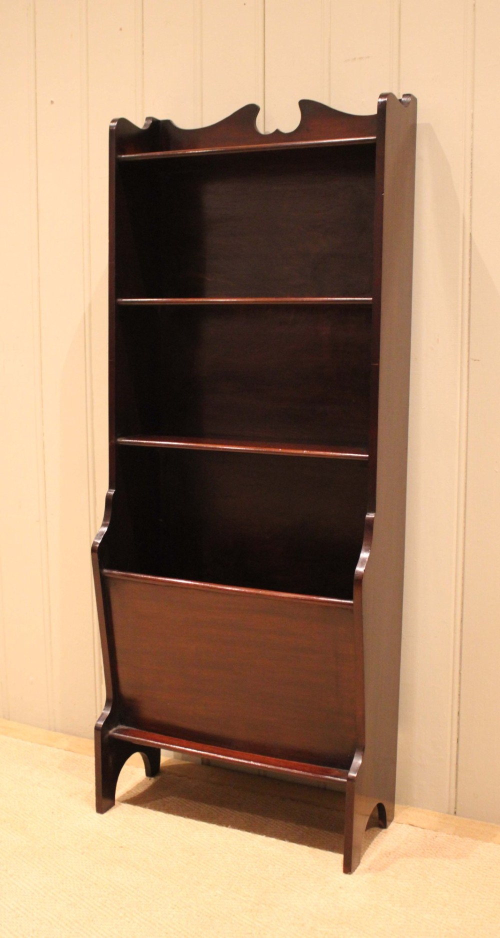 A narrow dark mahogany floor-standing shelf featuring two open upper book shelves and an angled lower magazine trough with a shaped top gallery. View VIII