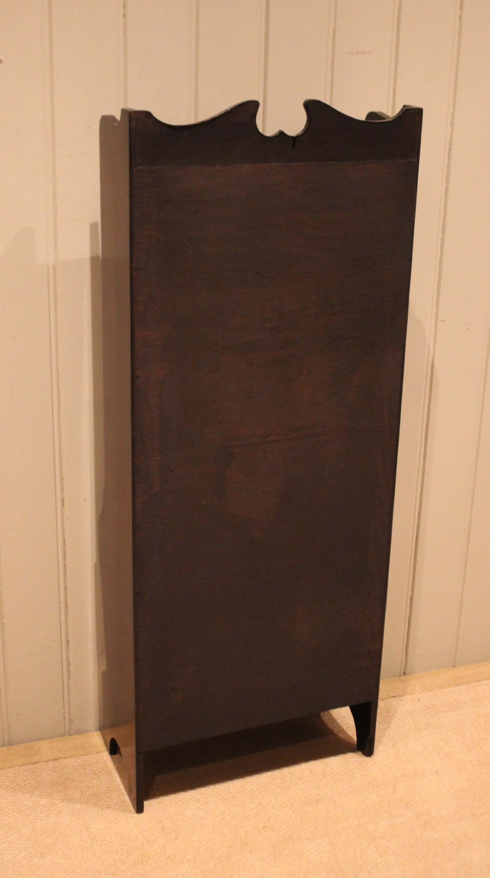 A narrow dark mahogany floor-standing shelf featuring two open upper book shelves and an angled lower magazine trough with a shaped top gallery. View XII