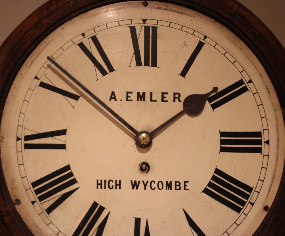 An antique circular wall clock featuring a turned dark beech frame, brass bezel, and painted white dial with Roman numerals. View VIII