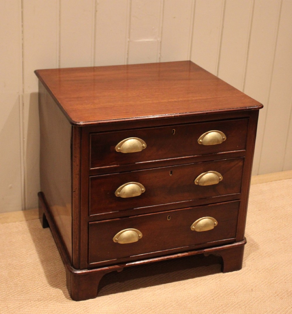 A mid-19th century small low mahogany chest of drawers featuring three graduated drawers with brass cup handles and bracket feet. View III