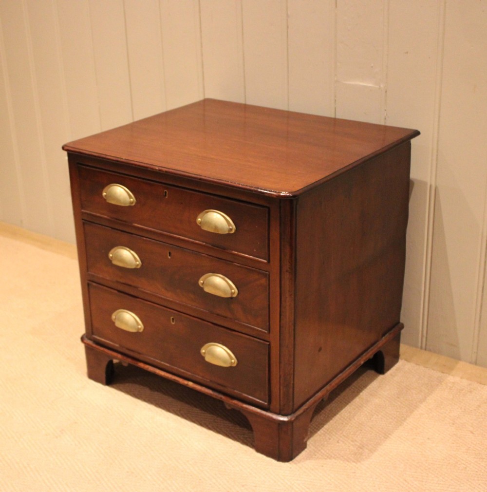 A mid-19th century small low mahogany chest of drawers featuring three graduated drawers with brass cup handles and bracket feet. View V