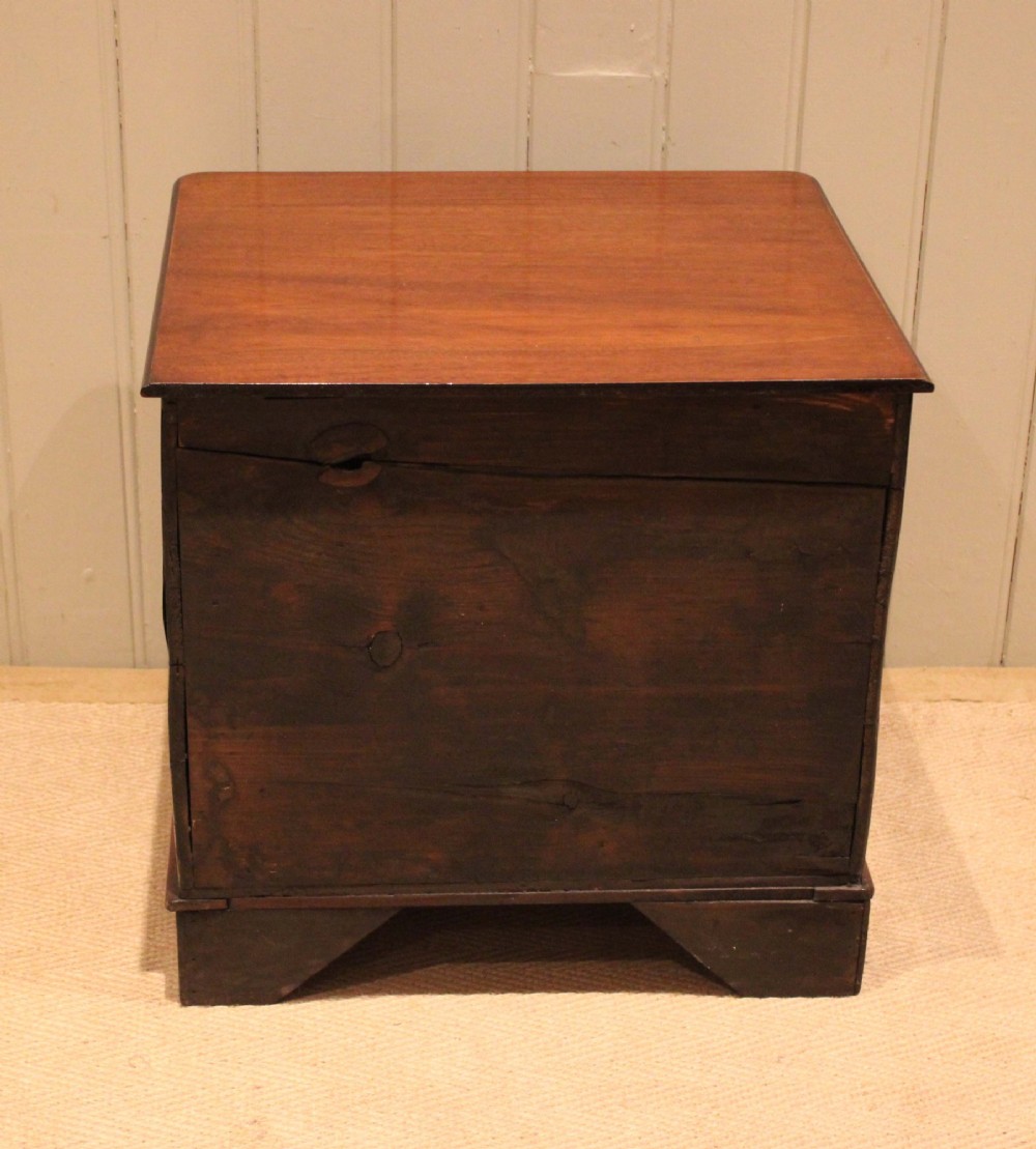 A mid-19th century small low mahogany chest of drawers featuring three graduated drawers with brass cup handles and bracket feet. View XII