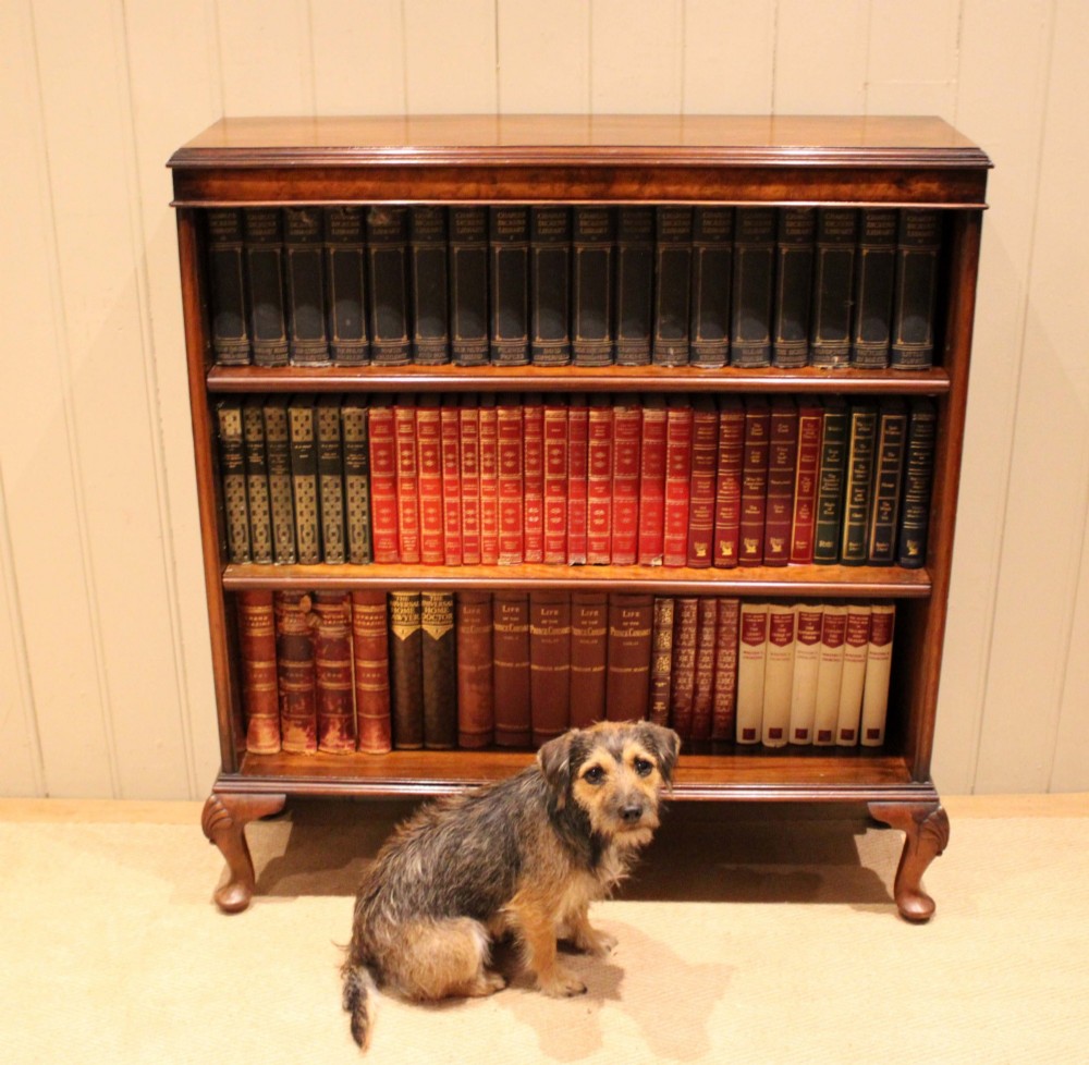 A low antique open walnut bookcase featuring three tiers of books and resting on carved cabriole legs. View XI