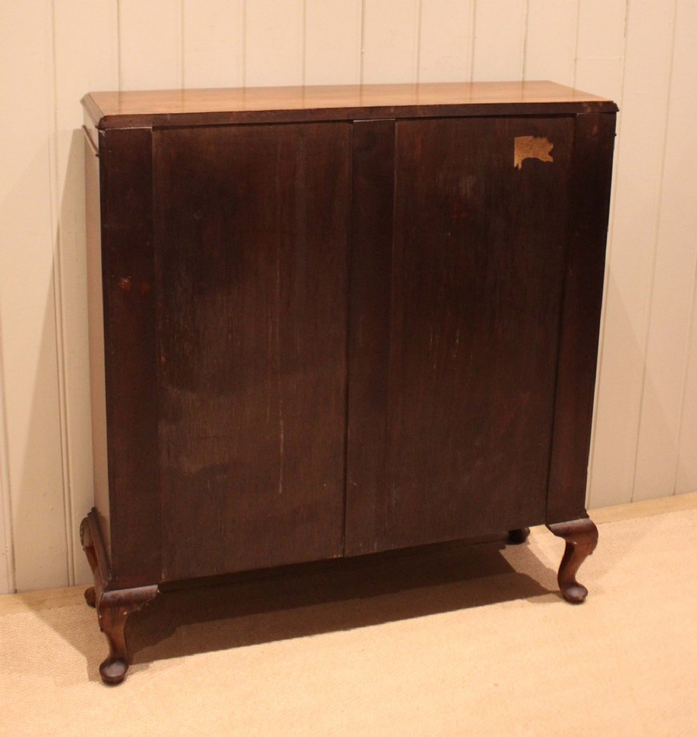 A low antique open walnut bookcase featuring three tiers of books and resting on carved cabriole legs. View XIII