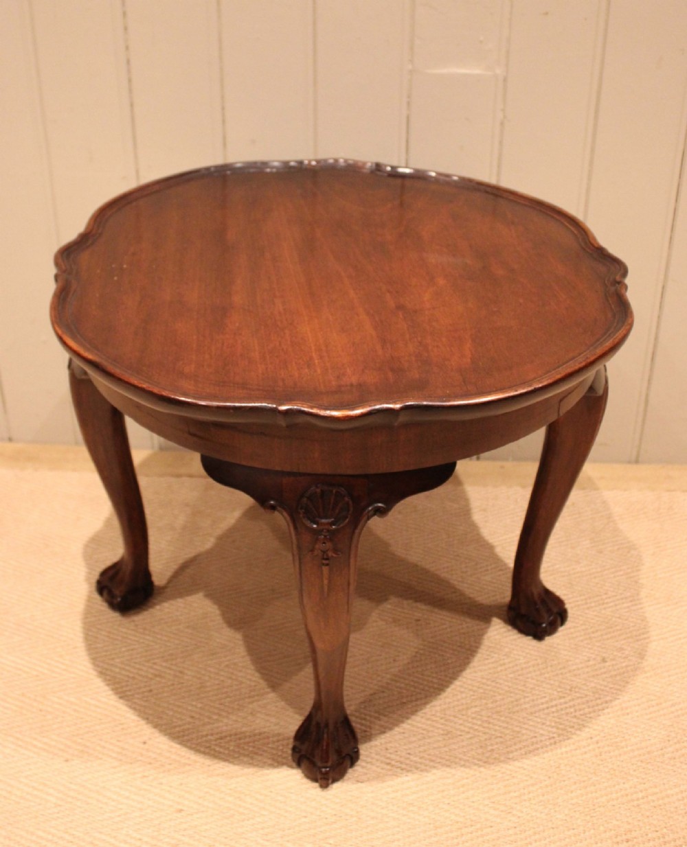 A low mahogany coffee table featuring a shaped piecrust rim, carved cabriole legs with shell knee detailing, and claw and ball feet. View II