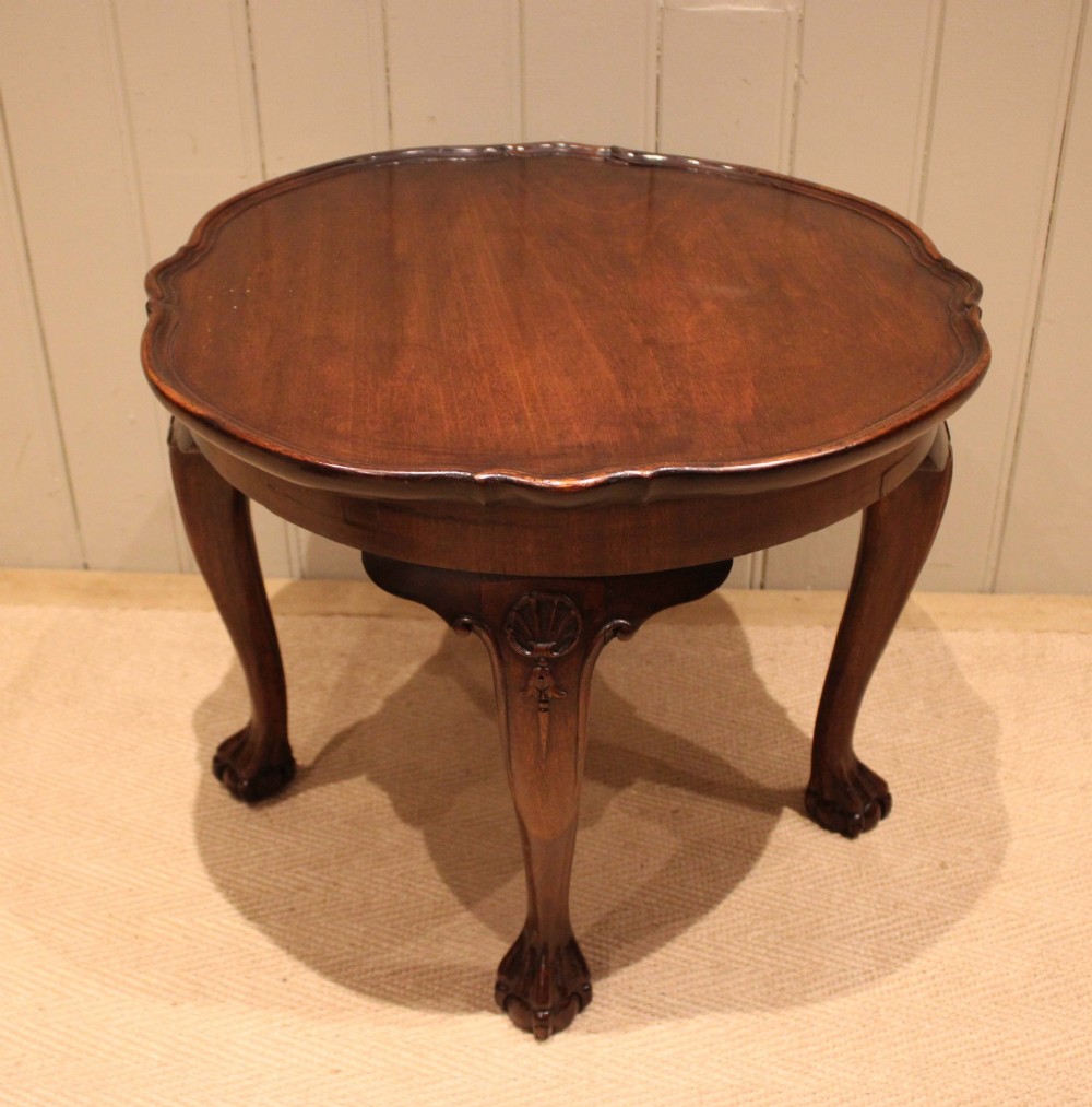 A low mahogany coffee table featuring a shaped piecrust rim, carved cabriole legs with shell knee detailing, and claw and ball feet. View IV