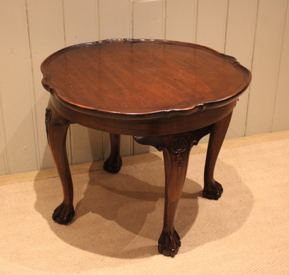 A low mahogany coffee table featuring a shaped piecrust rim, carved cabriole legs with shell knee detailing, and claw and ball feet. View V