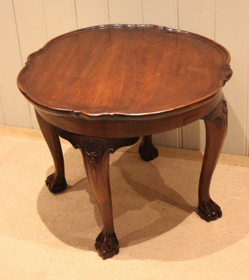 A low mahogany coffee table featuring a shaped piecrust rim, carved cabriole legs with shell knee detailing, and claw and ball feet. View VII