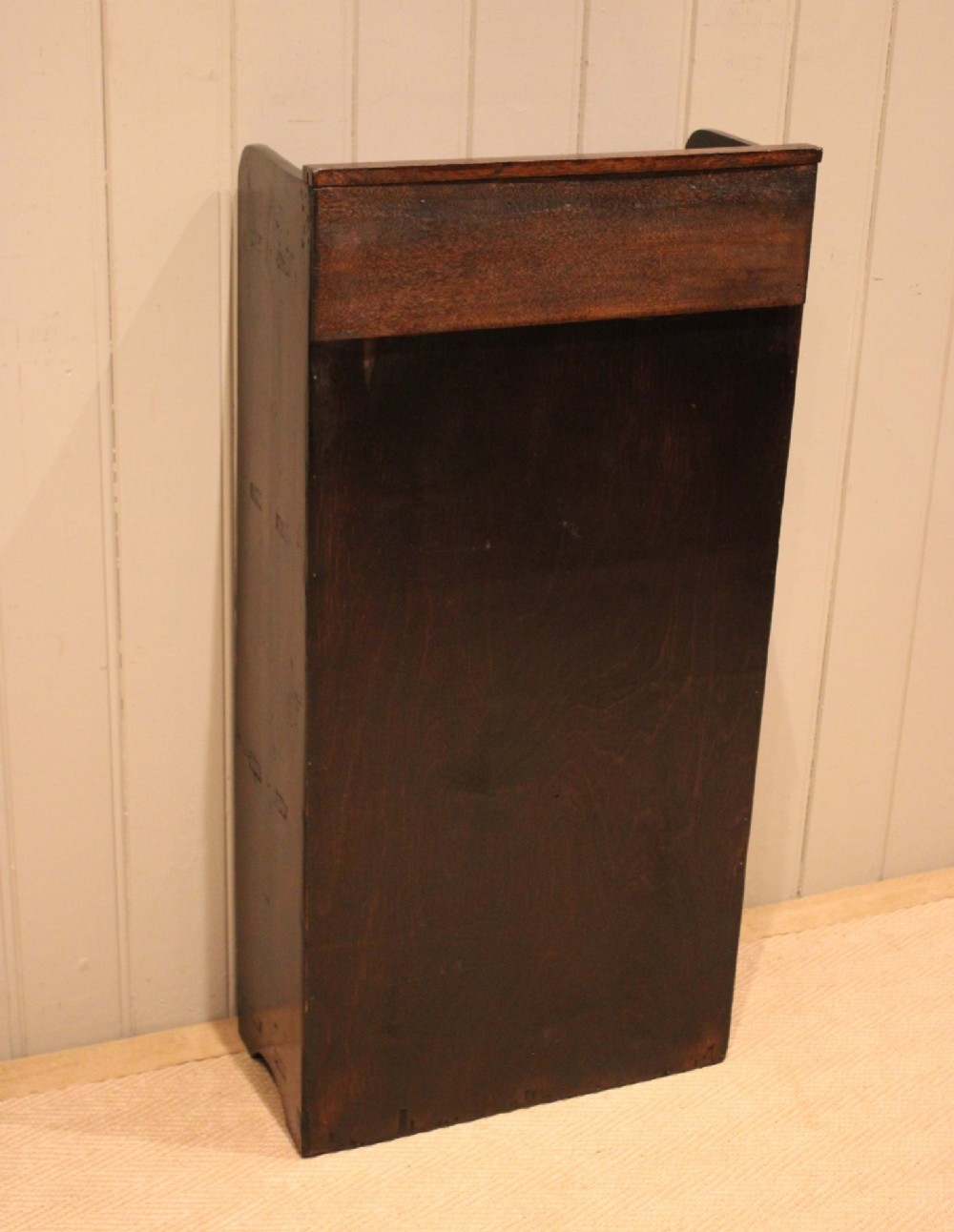 A small dark pine open bookcase featuring three fixed shelves, solid side panels with visible tenon joinery, and a simple shaped gallery top. View XIII