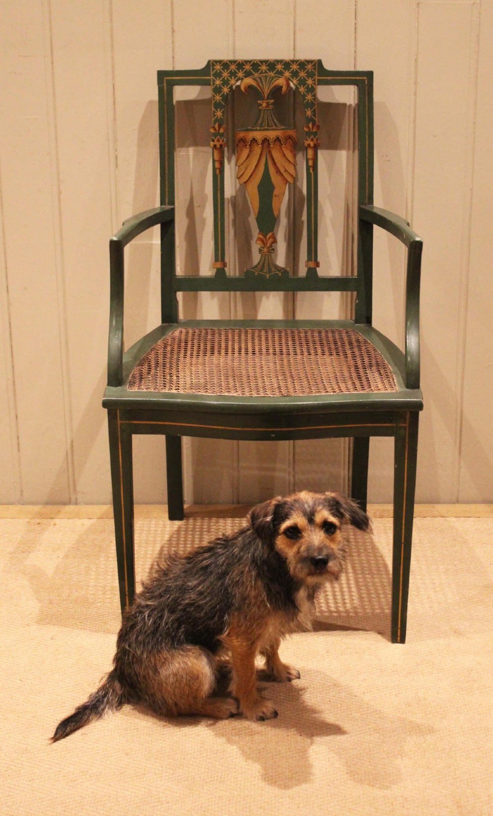 A dark green painted Hepplewhite style armchair featuring a woven cane seat, curved armrests, and hand-painted neoclassical motifs on the backrest. View VI