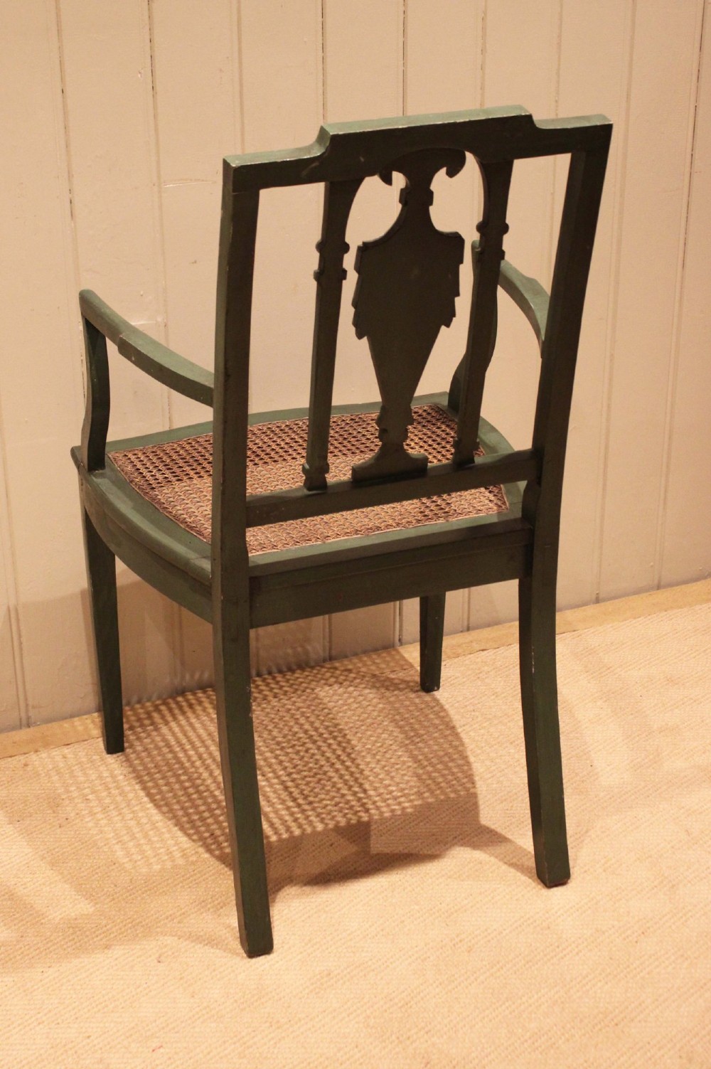 A dark green painted Hepplewhite style armchair featuring a woven cane seat, curved armrests, and hand-painted neoclassical motifs on the backrest. View IX
