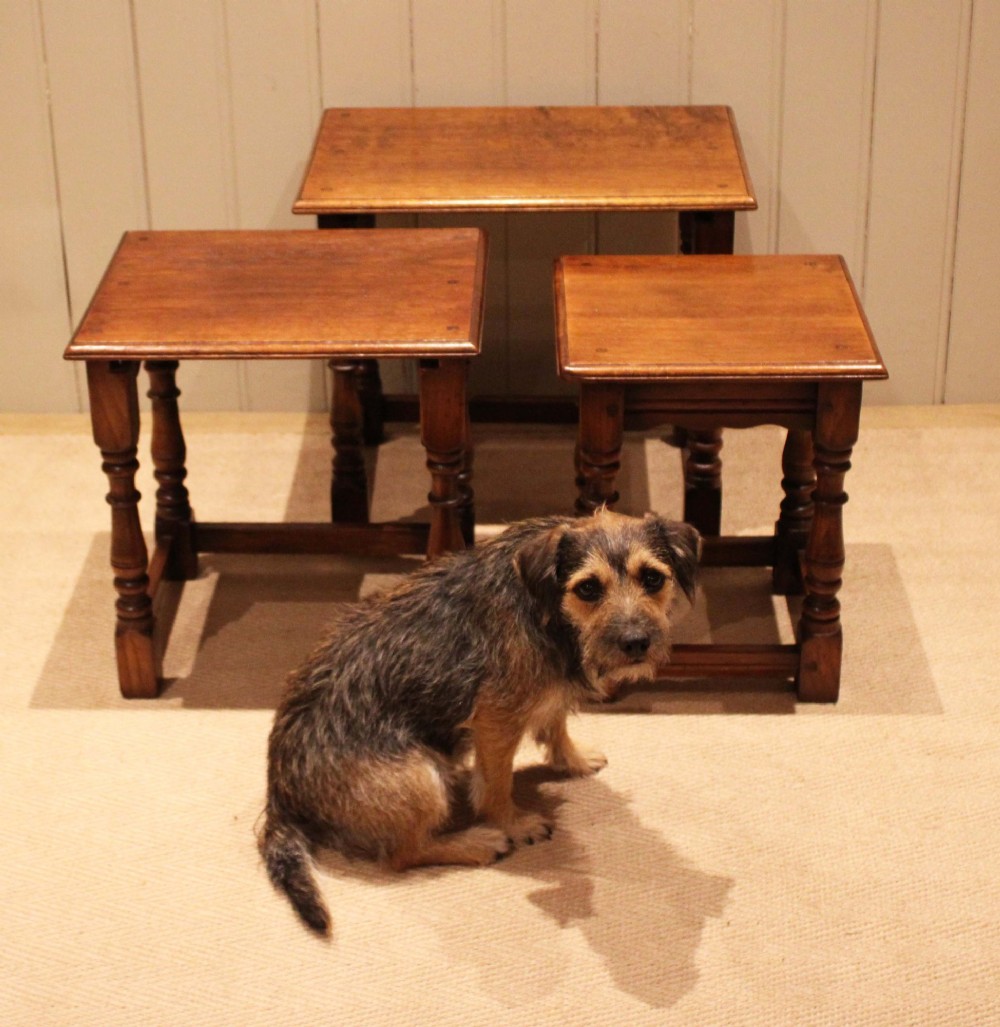 A set of three graduating solid oak nesting tables featuring turned legs, box stretchers, and rectangular molded tops. View VIII