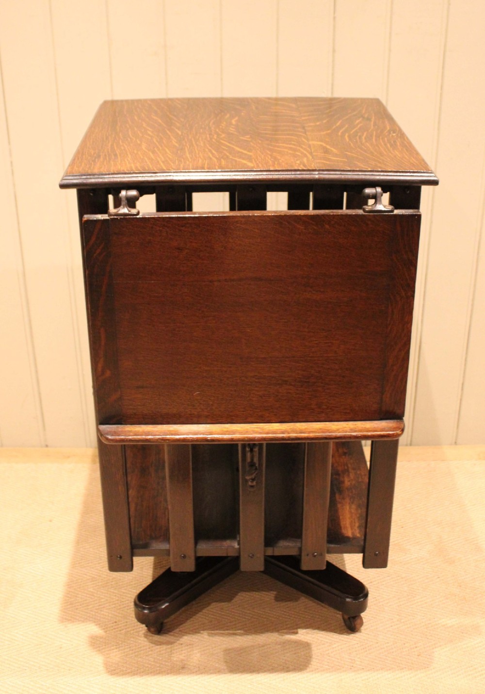 A dark oak revolving bookcase featuring vertical slatted sides, an adjustable reading lectern, and a four-point base on castors. View II