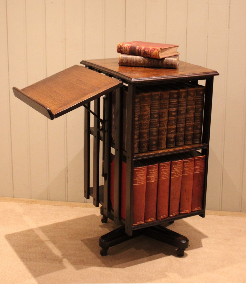 A dark oak revolving bookcase featuring vertical slatted sides, an adjustable reading lectern, and a four-point base on castors. View V