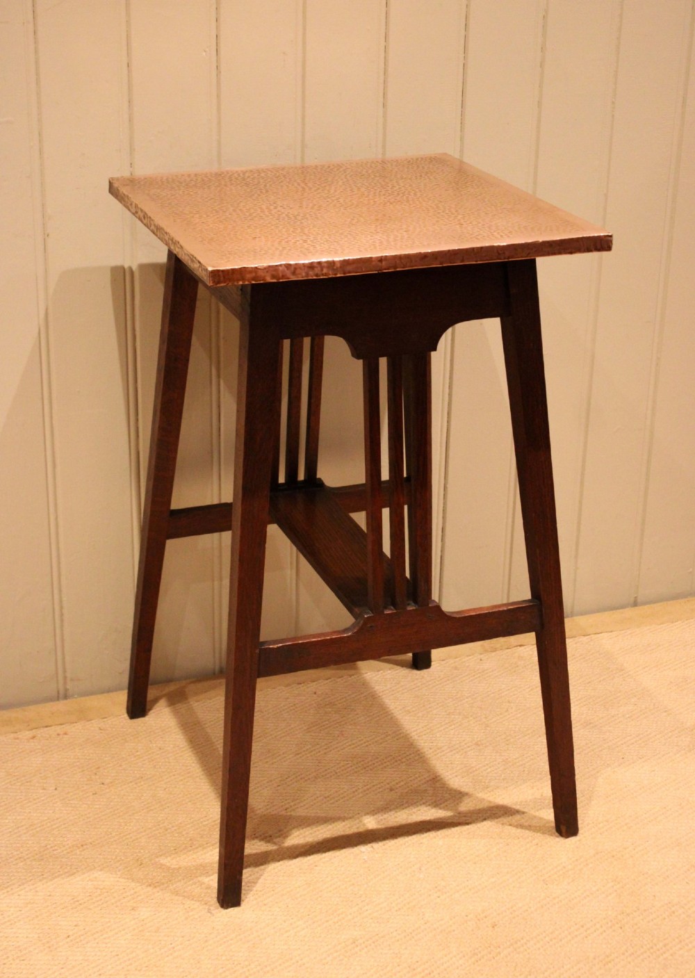 A square Arts and Crafts side table made of dark oak with a hand-hammered copper top, tapered legs, vertical slats, and cross stretchers. View II