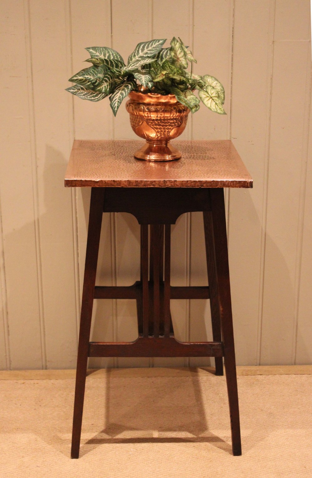 A square Arts and Crafts side table made of dark oak with a hand-hammered copper top, tapered legs, vertical slats, and cross stretchers. View III