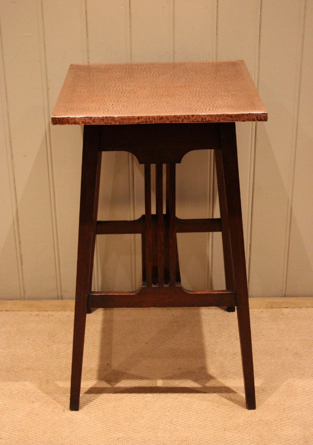 A square Arts and Crafts side table made of dark oak with a hand-hammered copper top, tapered legs, vertical slats, and cross stretchers. View V