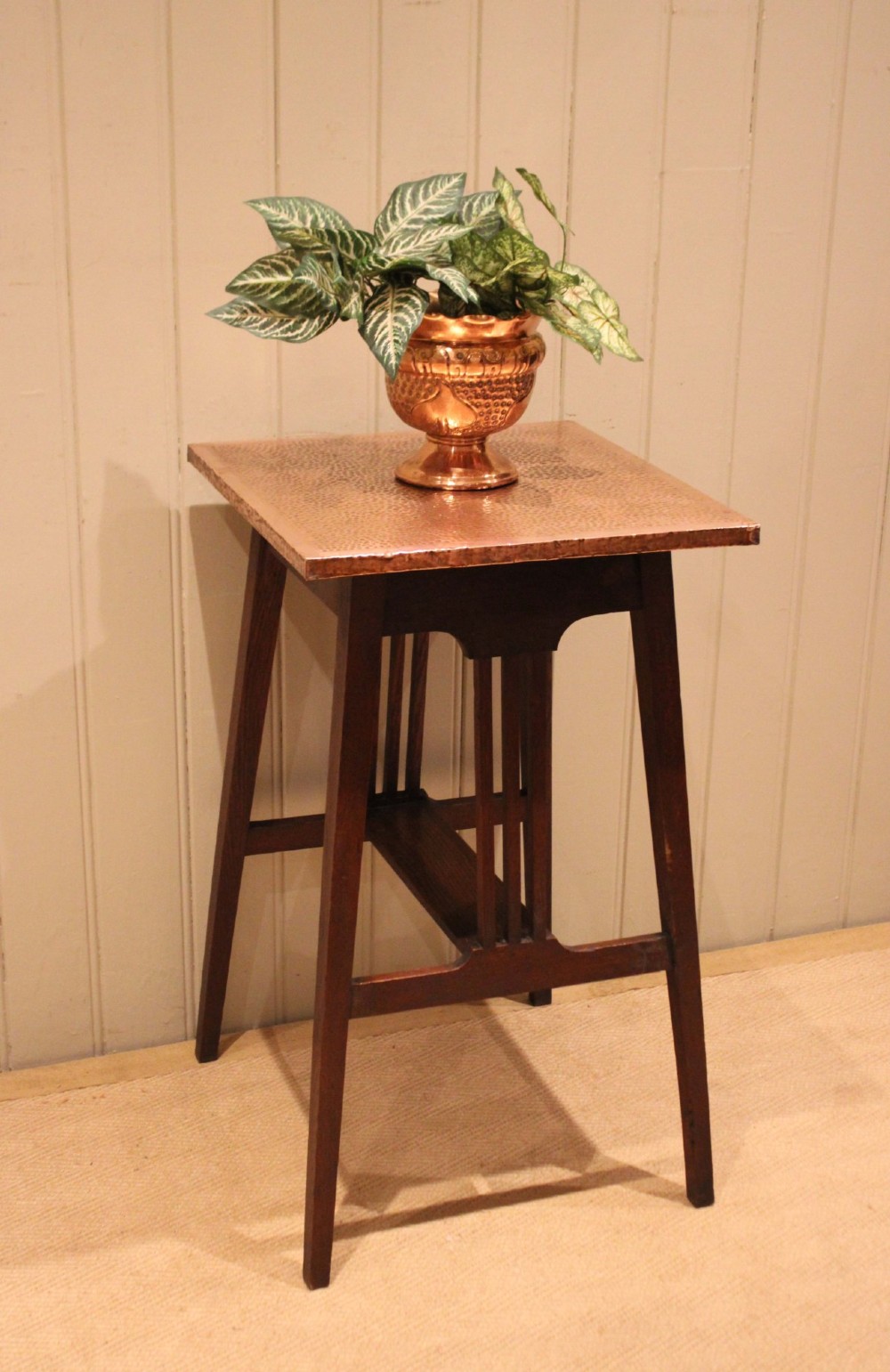 A square Arts and Crafts side table made of dark oak with a hand-hammered copper top, tapered legs, vertical slats, and cross stretchers. View VI