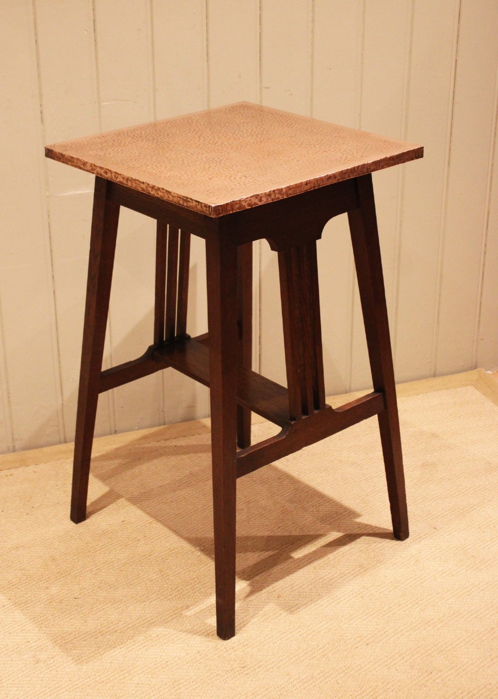 A square Arts and Crafts side table made of dark oak with a hand-hammered copper top, tapered legs, vertical slats, and cross stretchers. View VII