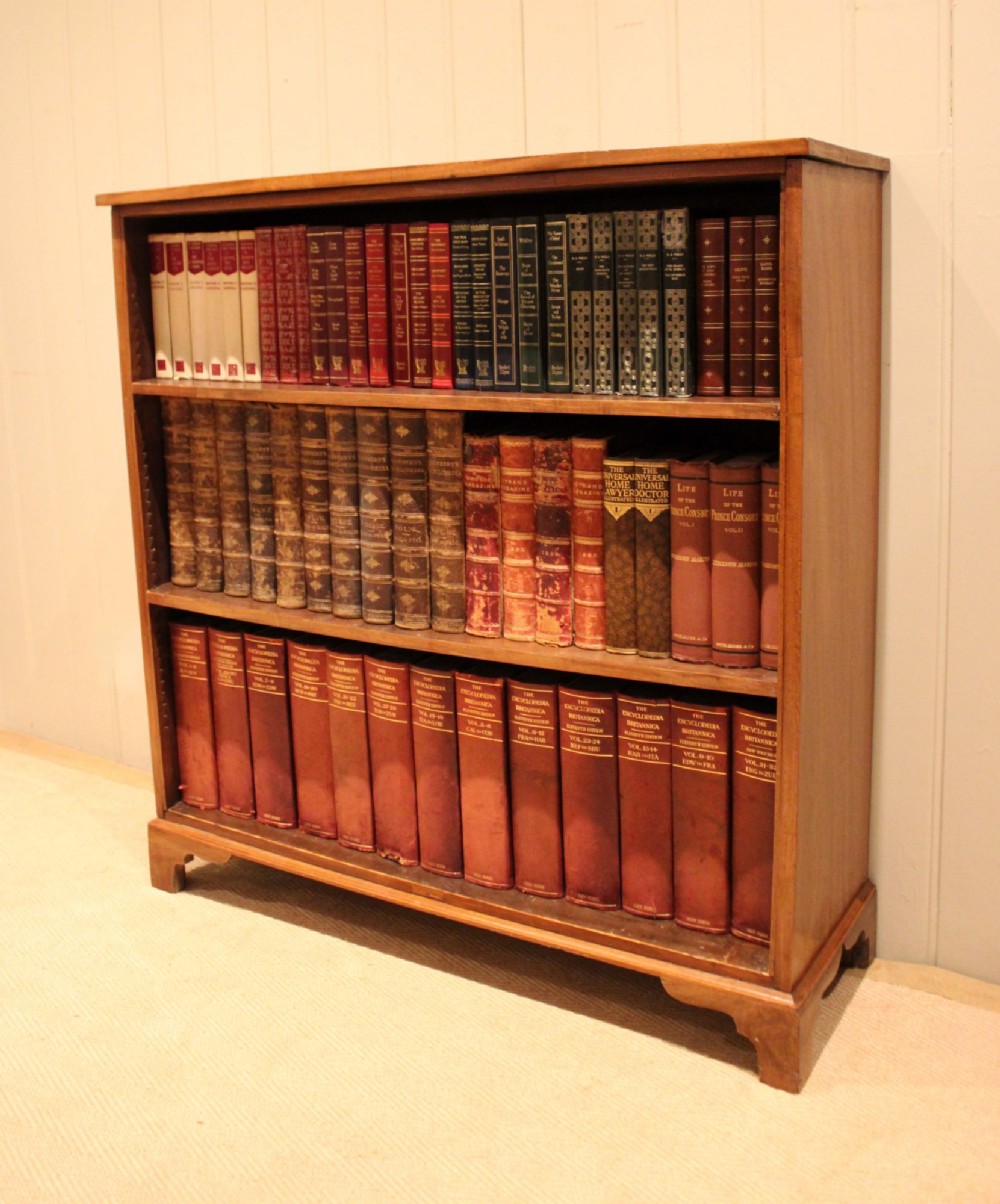 A late nineteenth-century mahogany open bookcase featuring three wide horizontal shelves and bracket feet.