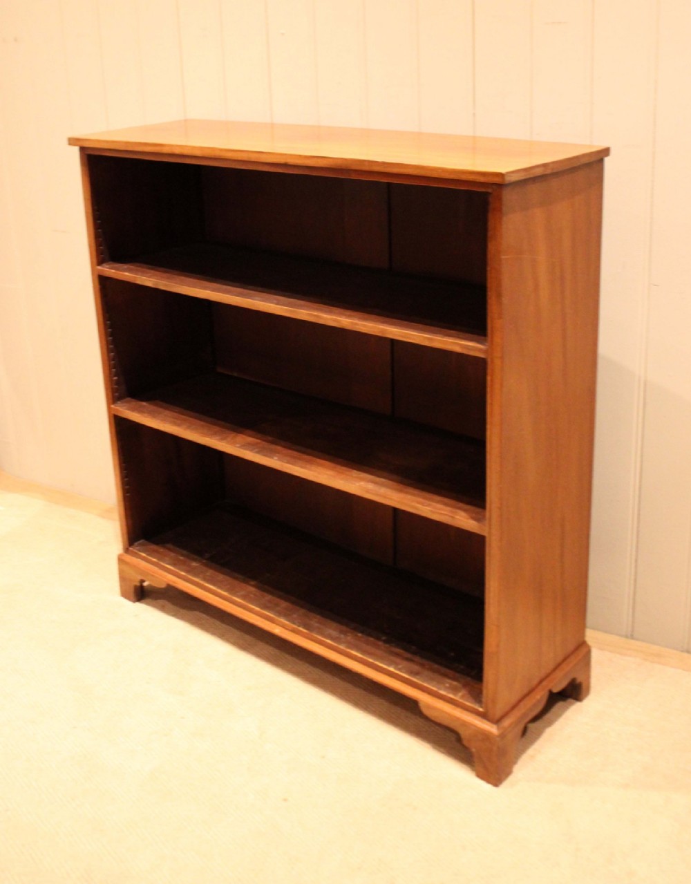 A late nineteenth-century mahogany open bookcase featuring three wide horizontal shelves and bracket feet. View IV