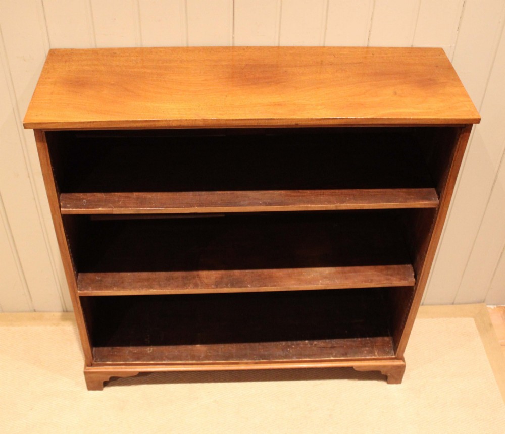 A late nineteenth-century mahogany open bookcase featuring three wide horizontal shelves and bracket feet. View VI
