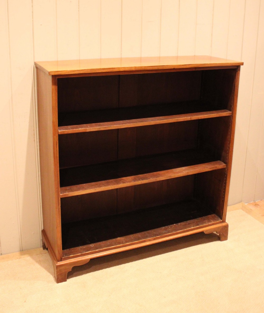 A late nineteenth-century mahogany open bookcase featuring three wide horizontal shelves and bracket feet. View X