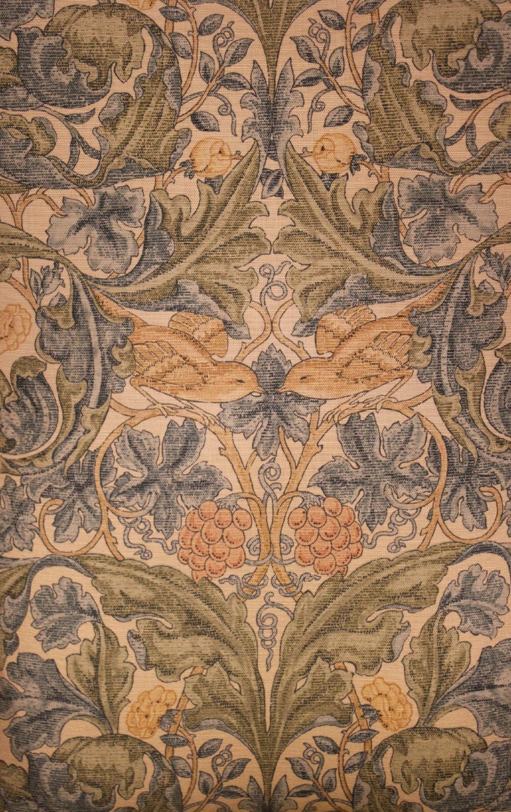 A solid oak Arts and Crafts style armchair featuring broad flat armrests and upholstery decorated with a botanical foliage pattern. View XII